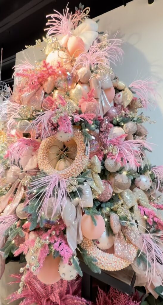 Pink glam Easter tree decorated with blush ornaments, feather sprays, soft ribbon, and pastel egg accents for spring.