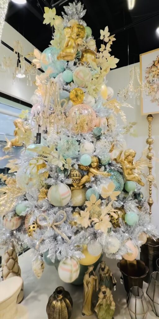 White Christmas tree decorated as an elegant Easter tree with pastel ornaments, gold cherub decorations, and soft spring florals