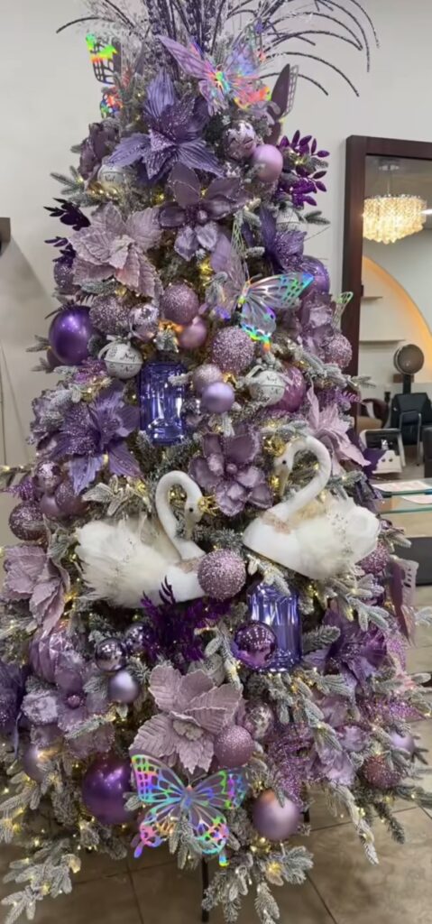 Purple Easter tree decorated with butterflies, lavender flowers, glitter ornaments, and white swan decorations for a spring theme