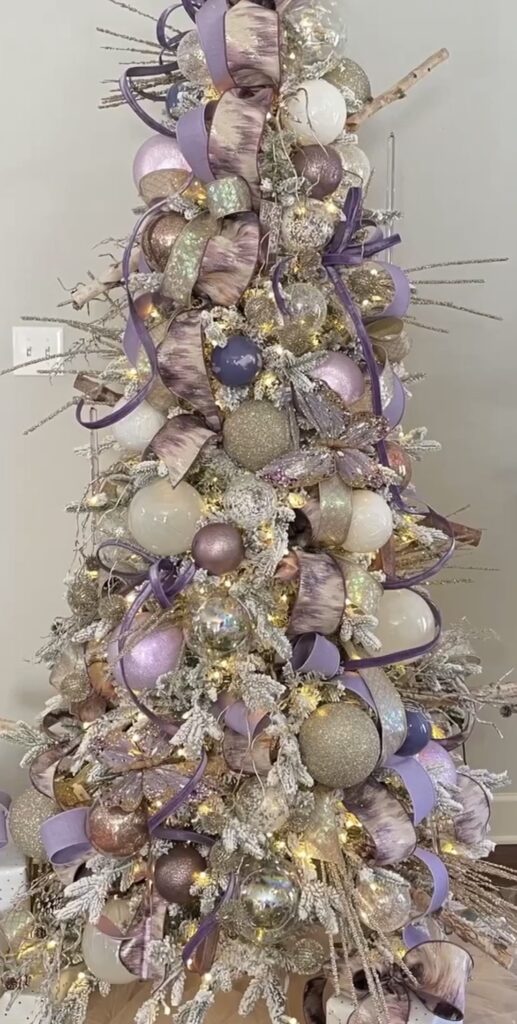 Purple Easter tree decorated with butterflies, lavender flowers, glitter ornaments, and white swan decorations for a spring theme