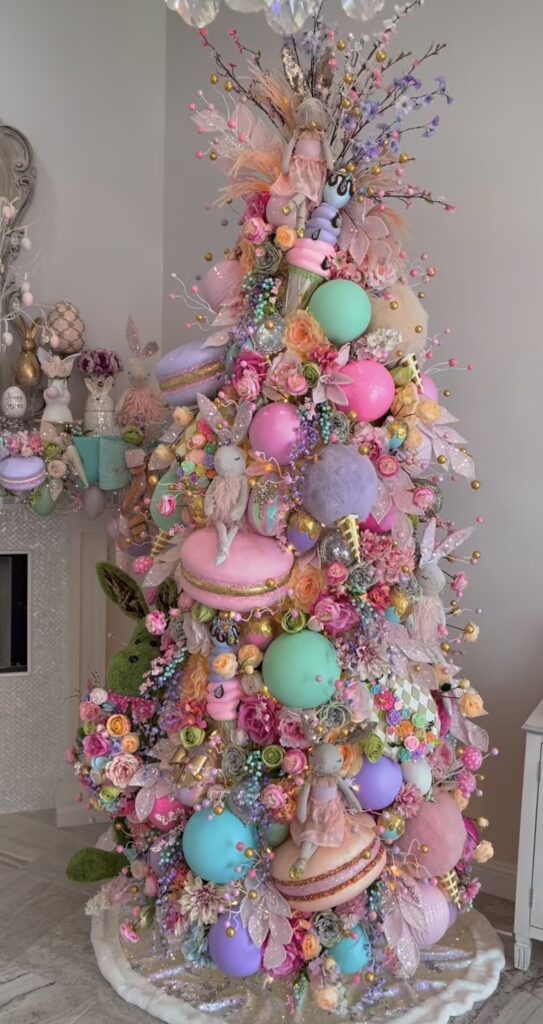 Candy-colored Easter tree decorated with giant pastel ornaments, macaron accents, florals, glittery stems, and fairy garden details.