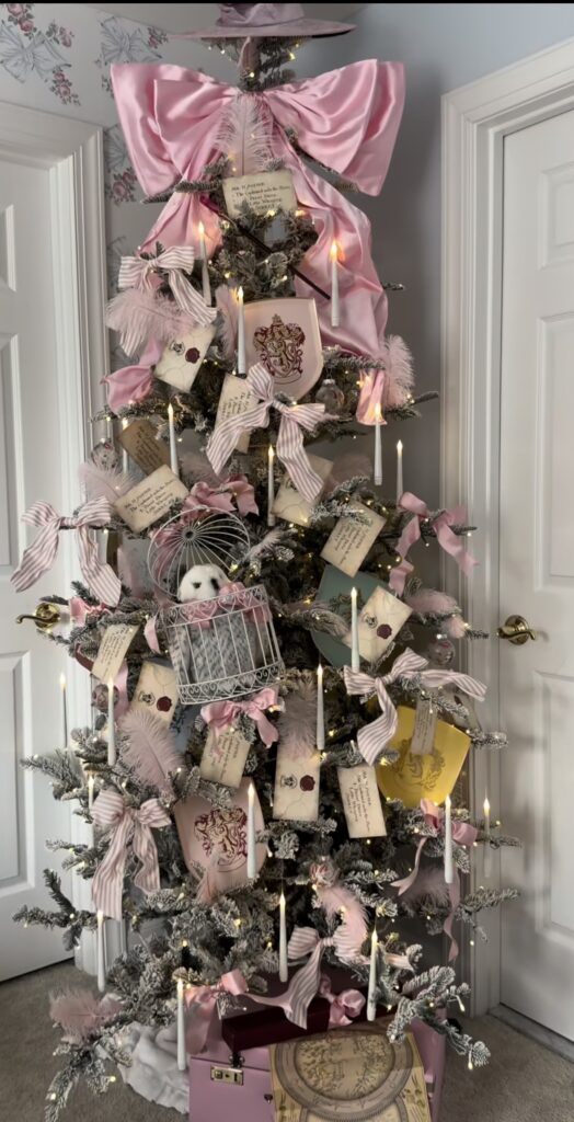 Pink Harry Potter themed tree decorated with a giant pink bow, floating candle lights, and letter ornaments for a magical look