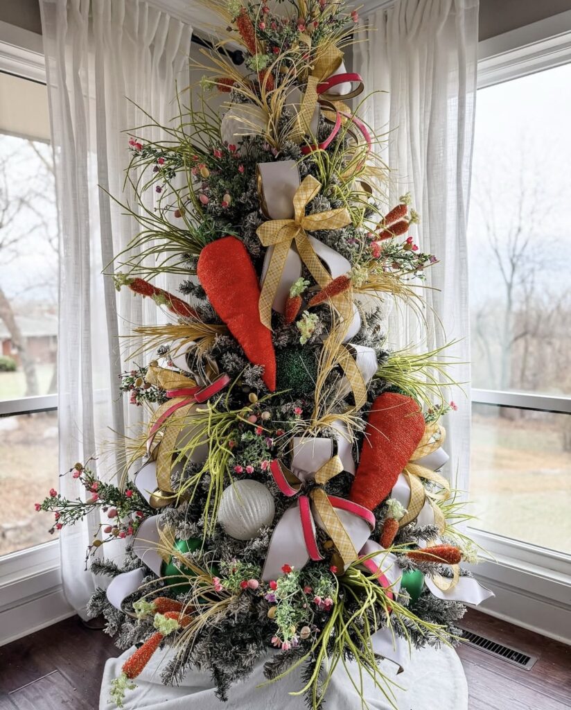 Easter tree decorated with oversized carrot ornaments, greenery sprays, pink berry stems, and spring ribbon bows