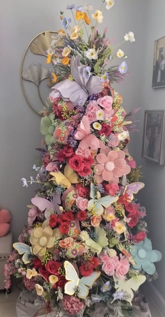 Bright spring Easter tree decorated with colorful flowers, large butterfly decorations, pastel blooms, and a soft garden theme