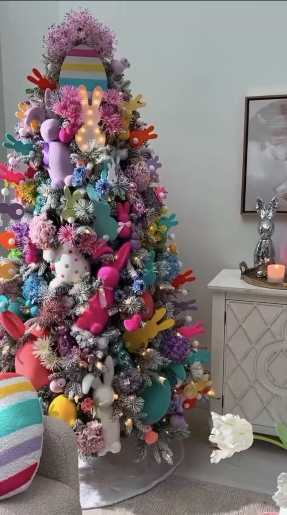 Bright colorful Easter tree with bunny-shaped ornaments, pom-pom florals, bold pastel eggs, and a light-up bunny topper.