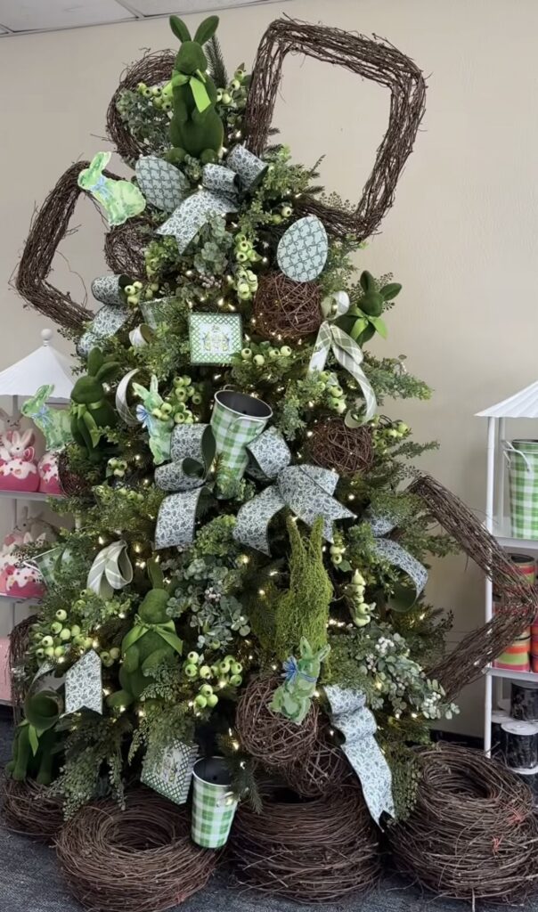 Rustic green Easter tree decorated with grapevine bunny ears, greenery picks, moss accents, and patterned ribbon bows