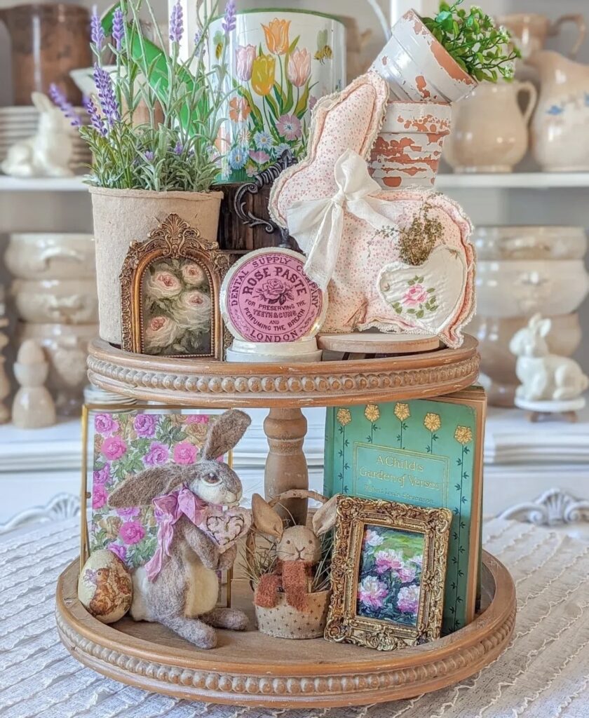 Cottagecore Easter tiered tray with vintage books, framed floral art, lavender greenery, soft bunny decor, and pastel spring accents.