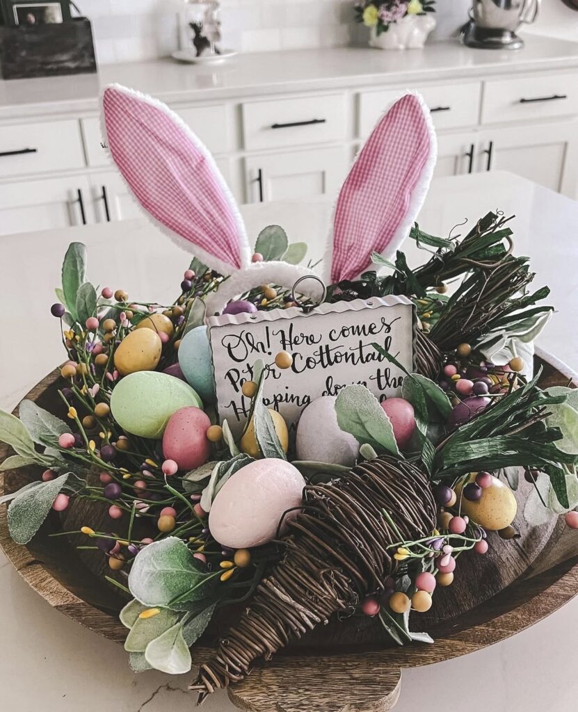 Colorful Easter tray centerpiece with pastel eggs, faux greenery, bunny ears sign, and spring themed decor arranged on a wooden tray