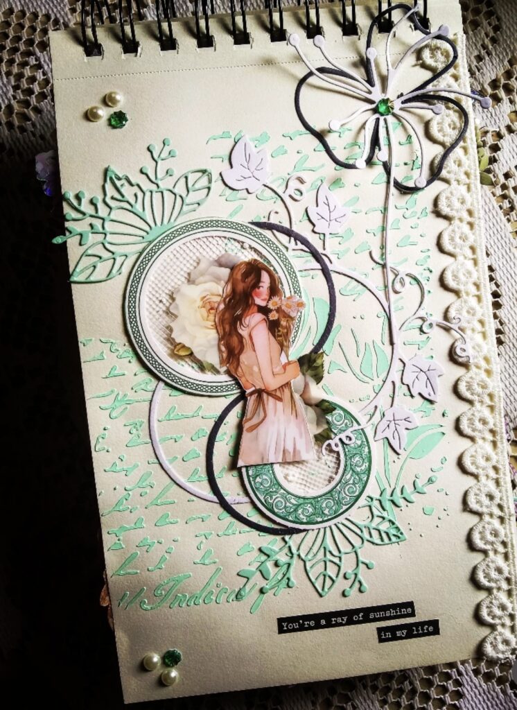 Cream and mint junk journal page with die-cut leaves, layered circles, butterfly embellishment, and a girl holding flowers.