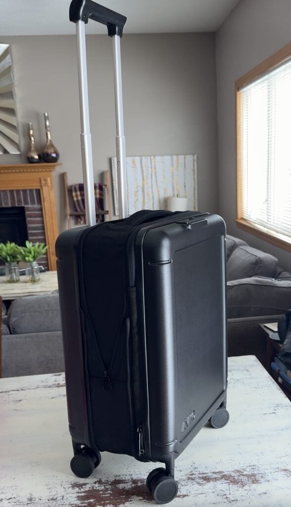 Avio collapsible carry on suitcase in black with extended handle displayed on a table in a home living room