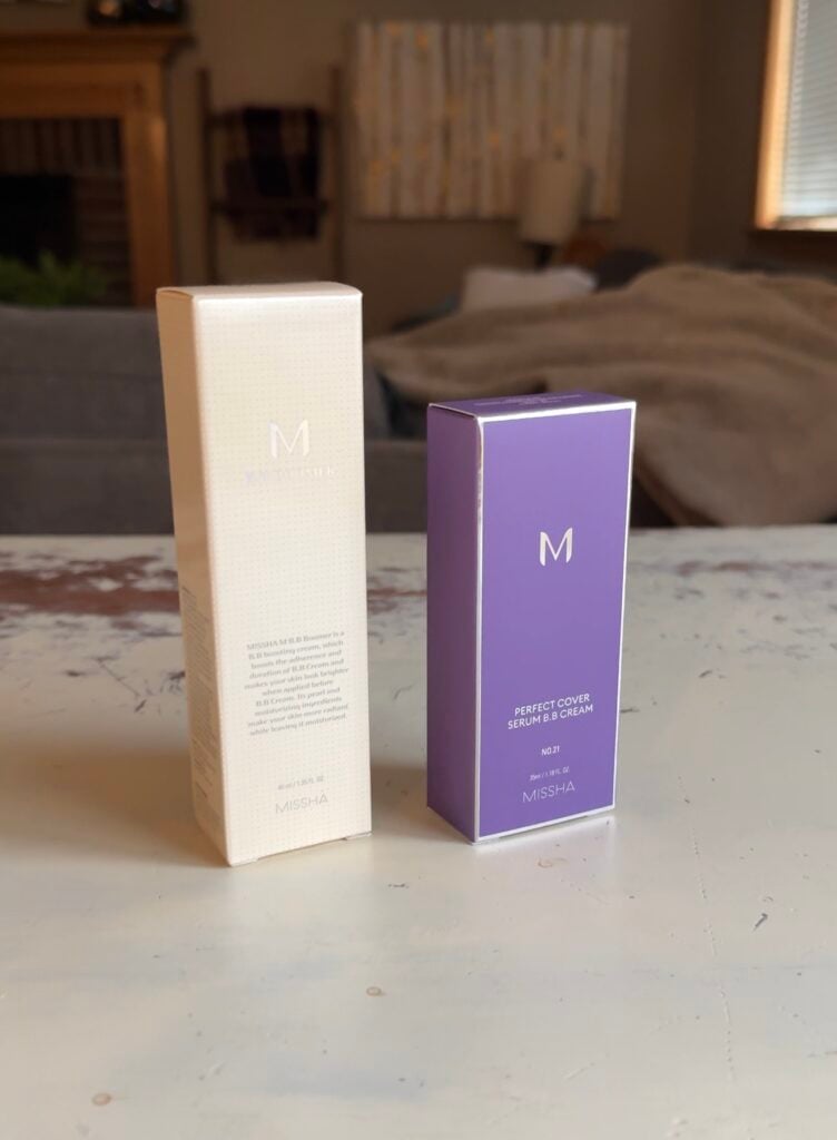 Missha BB cream and primer duo with BB Boomer and Perfect Cover Serum BB Cream boxes displayed on a table.