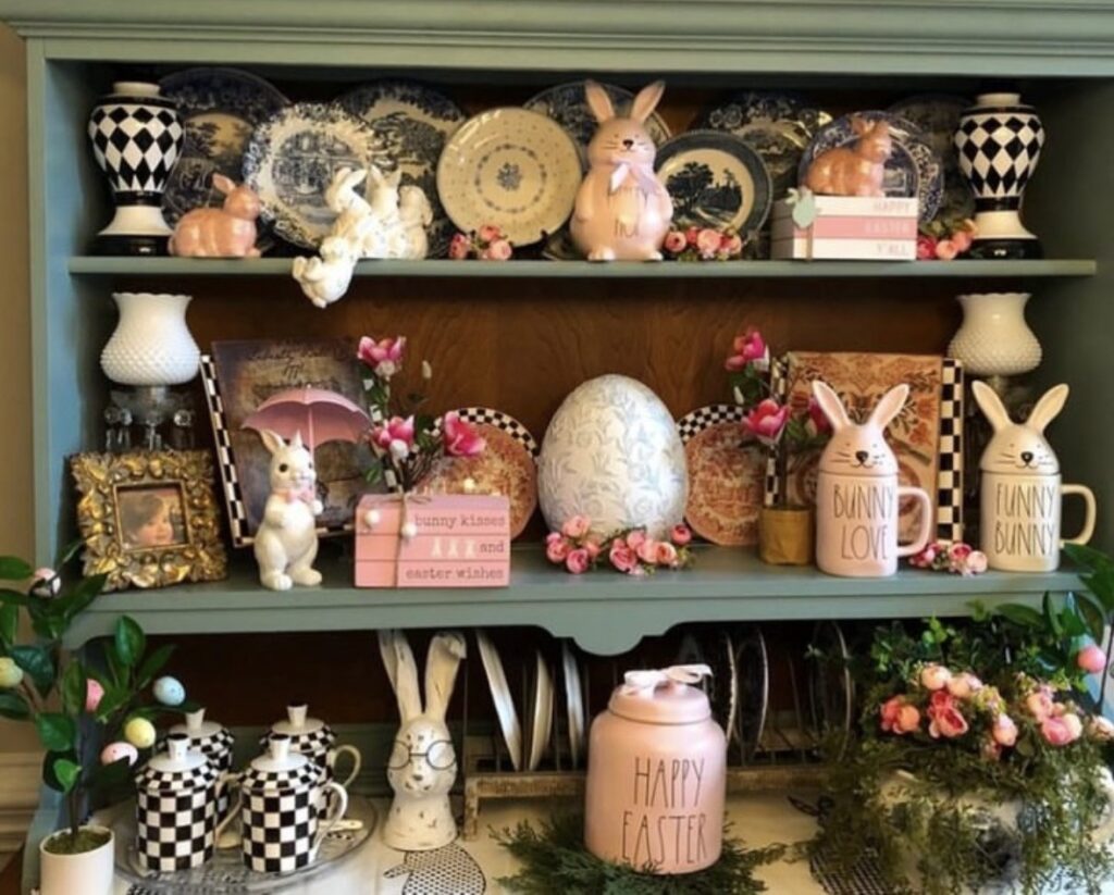 Colorful Easter hutch decor with pink bunny mugs, black and white check pieces, floral accents, pastel eggs, and a playful vintage-inspired spring display.
