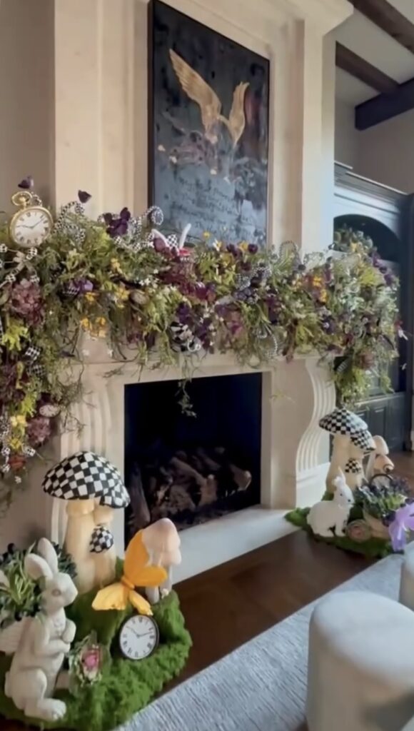 Soft neutral Easter mantel decor with a white fireplace, greenery garland, ceramic bunnies, wicker accents, and cozy spring living room styling.
