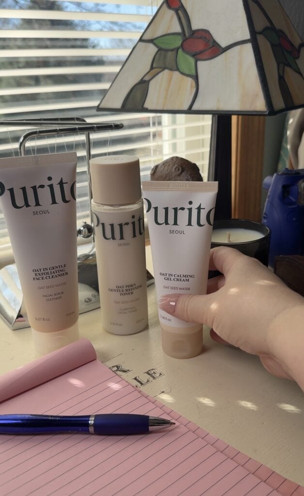 Purito Seoul Oat Seed Water skincare trio with cleanser, toner, and gel cream displayed on a desk near a window for a K-beauty skincare review.
