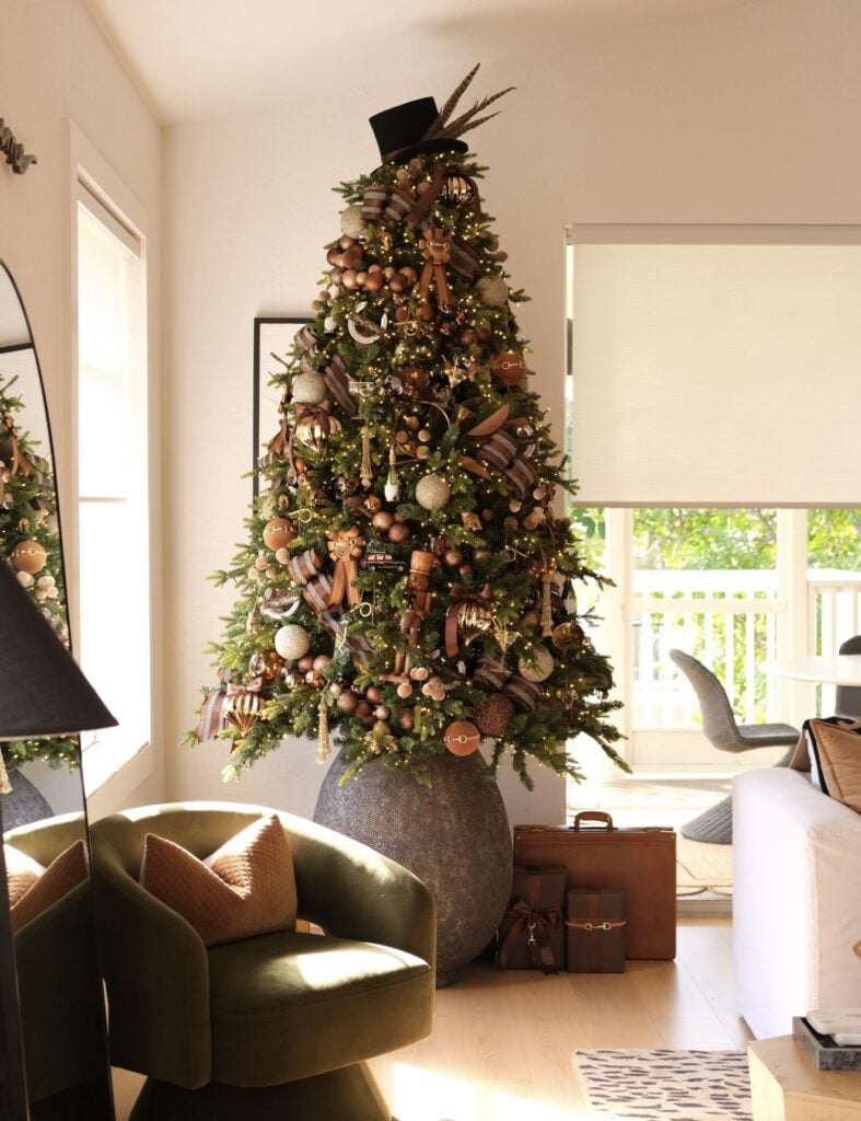 Christmas tree decorated in rich brown tones with elegant ornaments and festive details with felt hat topper