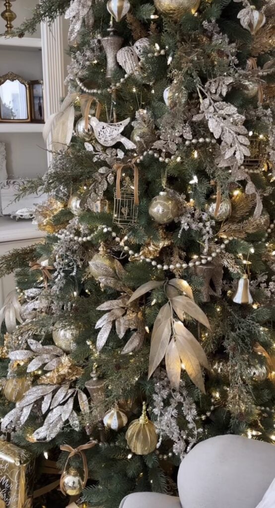 Classic gold Christmas tree with champagne ribbon, metallic ornaments, and elegant holiday decor.