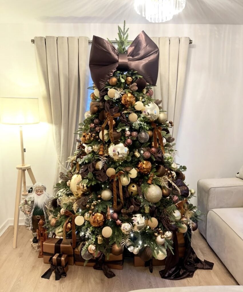 Christmas tree styling with oversized brown bow and layered brown ornaments and sophisticated neutral holiday decor