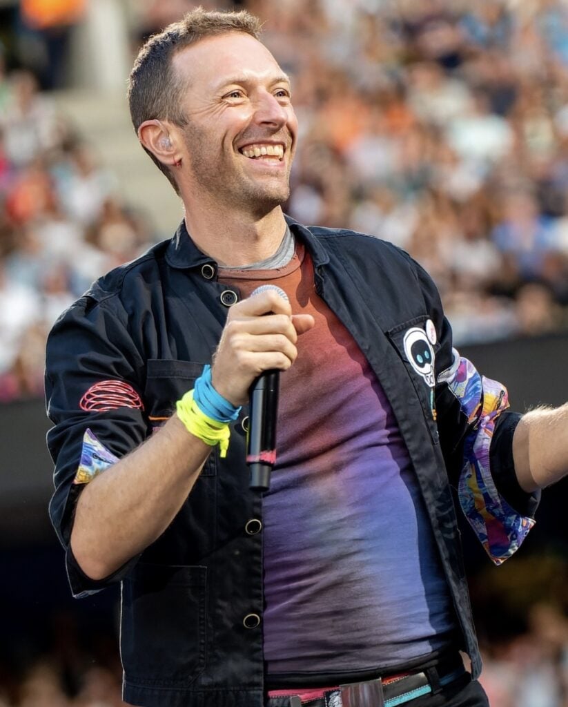 Chris Martin performing on stage during a Coldplay concert that inspired the viral kiss cam Halloween costume trend for 2026