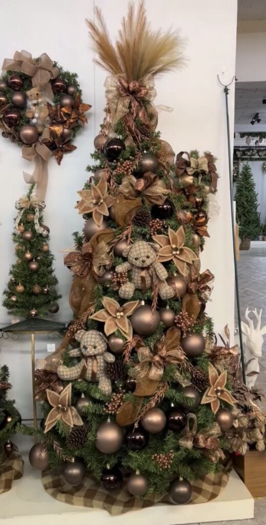 Tall Christmas tree decorated with brown teddy bear ornaments and warm elegant holiday accents