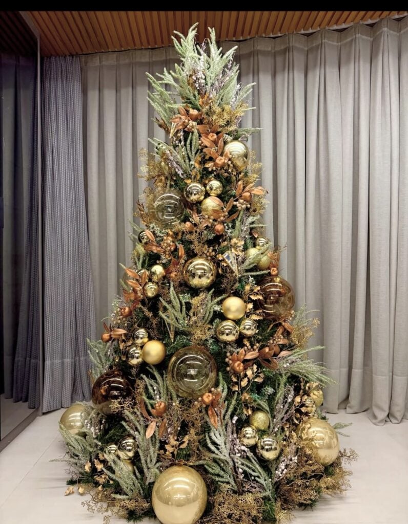 unusual Brown Christmas tree decorated with layered neutral ornaments and elegant seasonal accents