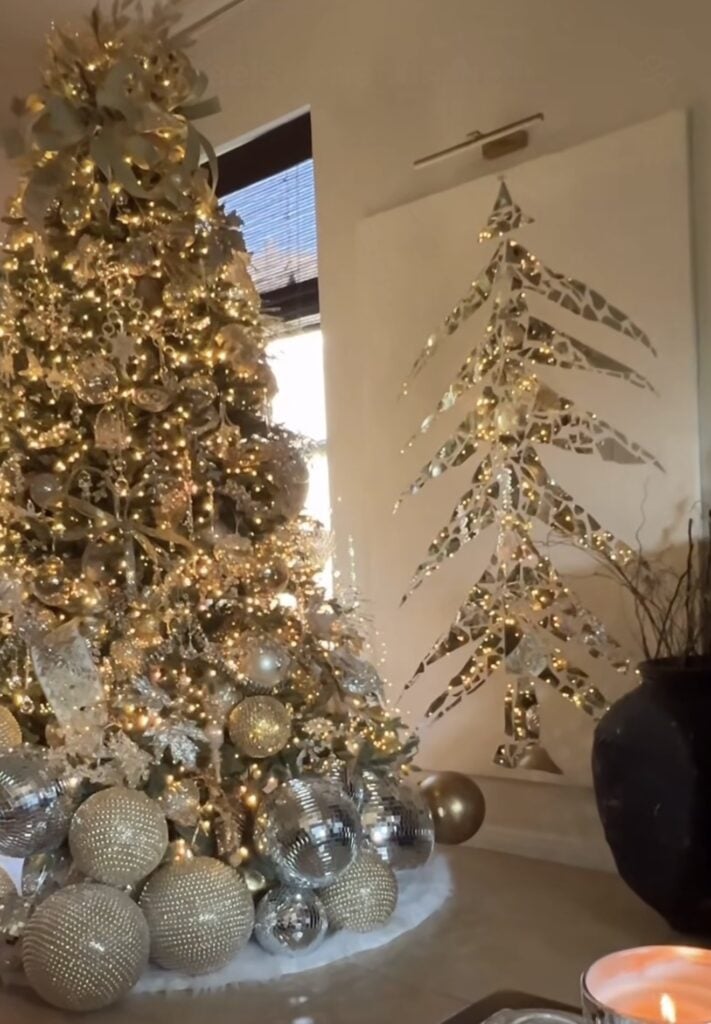 Gold-on-gold Christmas tree with champagne ornaments, oversized bow, and luxurious styling.