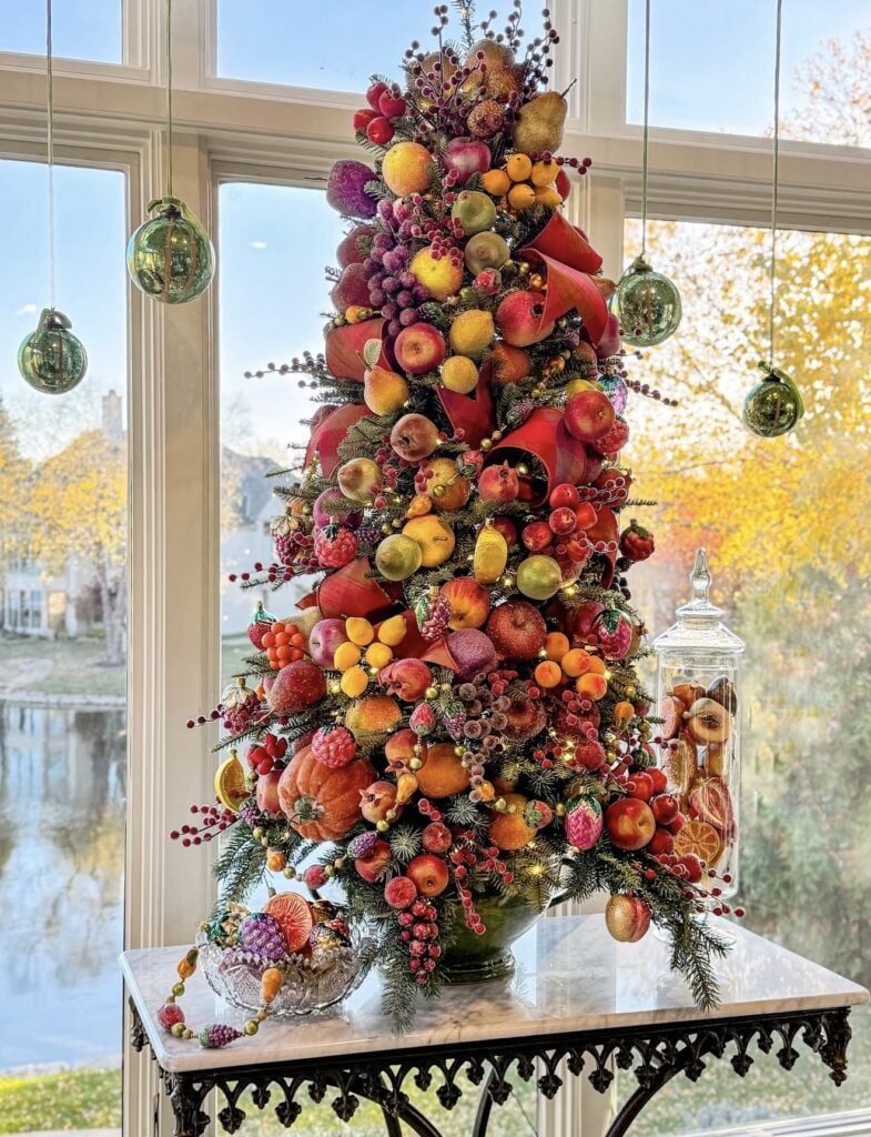 Winter Solstice tree decorated with colorful fruit, berries, pumpkins, citrus, and natural greenery inspired by the abundance of the harvest season.