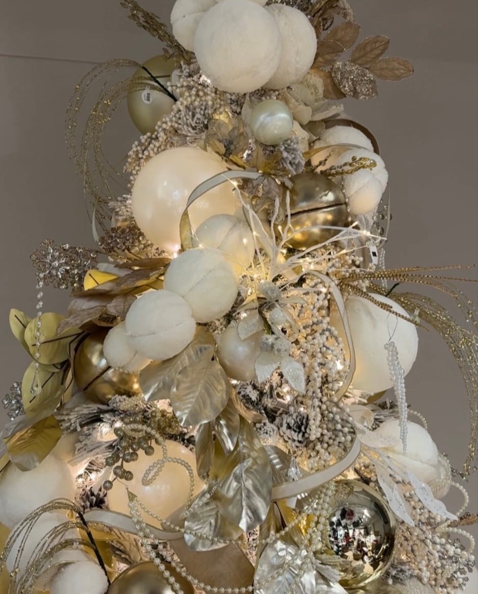 Designer gold Christmas tree with elegant metallic ornaments and sophisticated holiday decor.