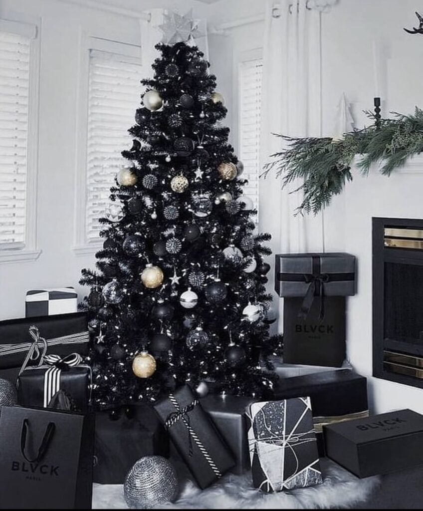 Black Christmas tree decorated with minimal gold and silver ornaments for a sleek, understated holiday look.