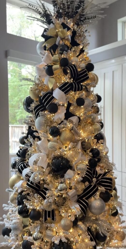 Black and white Christmas tree decorated with gold ornaments and metallic accents for a glamorous holiday look.