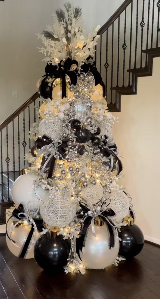 Black and white Christmas tree decorated with silver ornaments and sparkling metallic accents for an elegant holiday look.