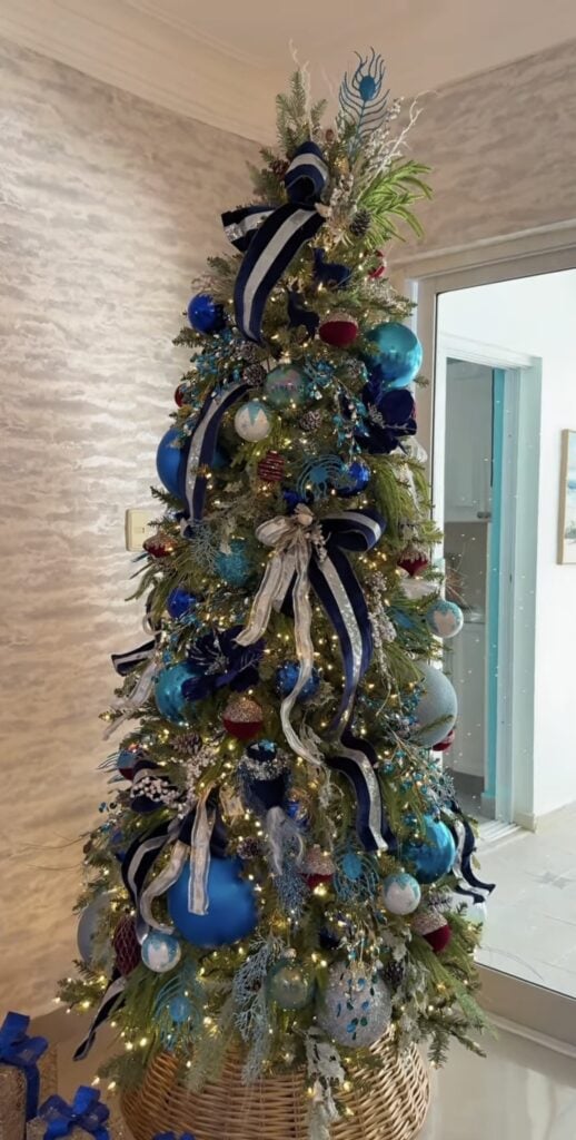 Christmas tree decorated with multiple shades of blue, including navy, royal blue, teal, and pale blue ornaments.