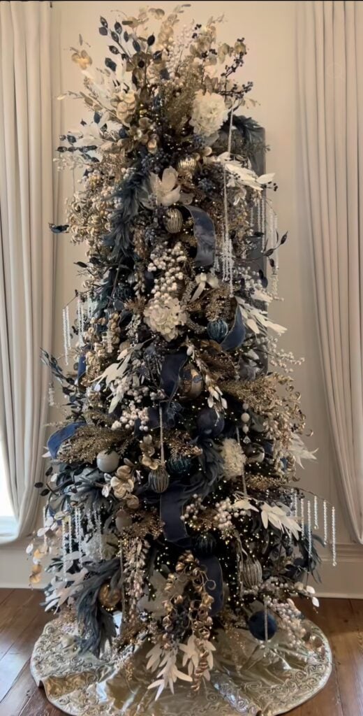 Blue Christmas tree decorated with hanging icicles, blue ornaments, frosted details, and shimmering winter accents.