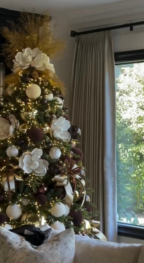 Christmas tree decorated in neutral tones with cream ornaments, warm metallic accents, ribbon, and soft natural textures.