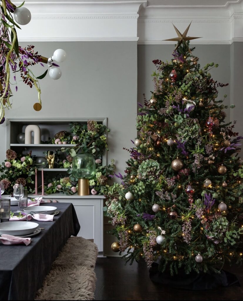 Floral Christmas tree filled with colorful flowers, leafy greenery, ornaments, and botanical accents woven through the branches.