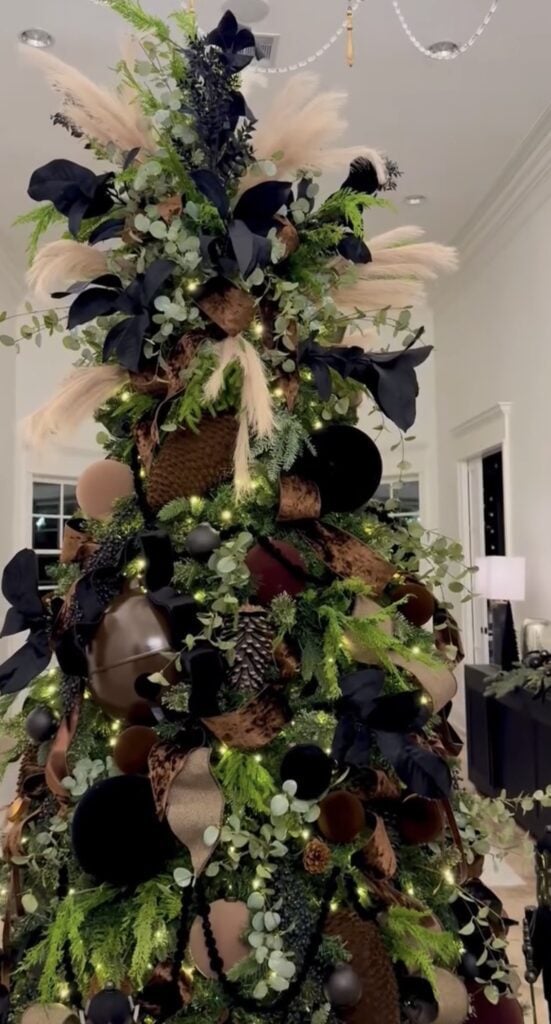 Christmas tree decorated with black and warm brown ornaments and accents for a rich, sophisticated holiday palette.