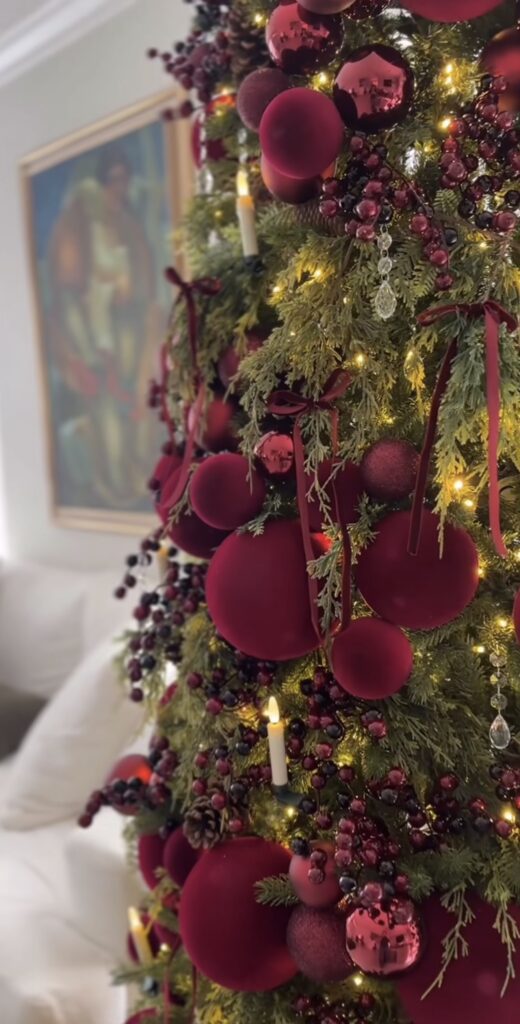 Elegant floral Christmas tree decorated with statement blooms, greenery, ornaments, and sophisticated botanical details.