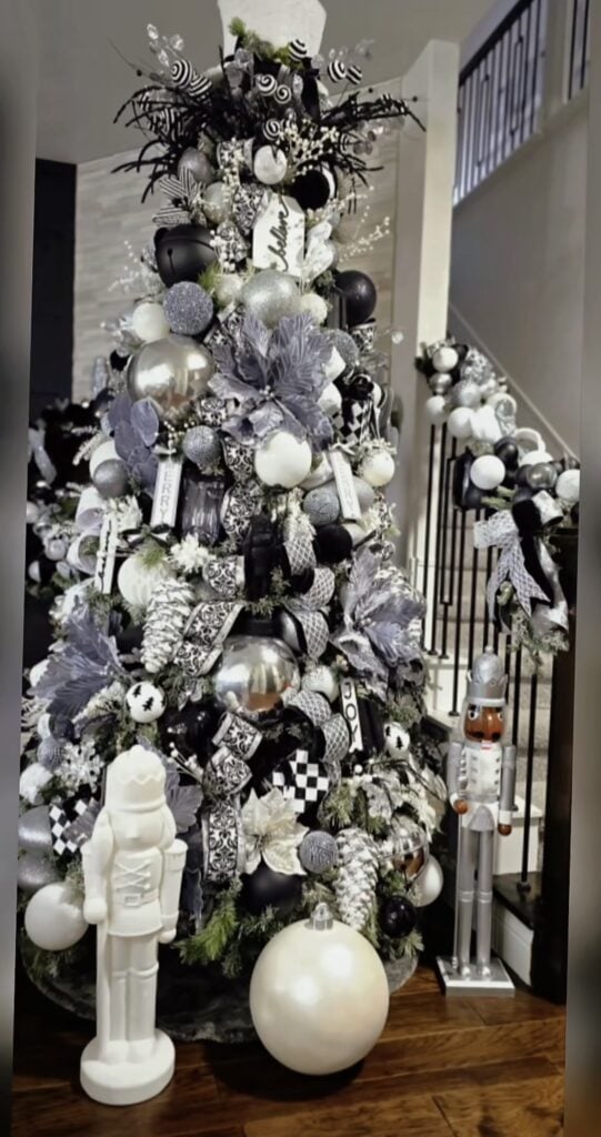 Glam black and white Christmas tree decorated with oversized ornaments, ribbon, warm lights, and elegant monochrome holiday accents.