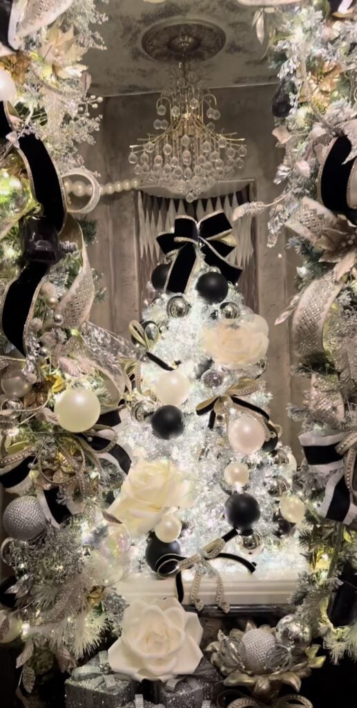 Grouping of three Christmas trees decorated in coordinating black and white themes for a dramatic holiday display.