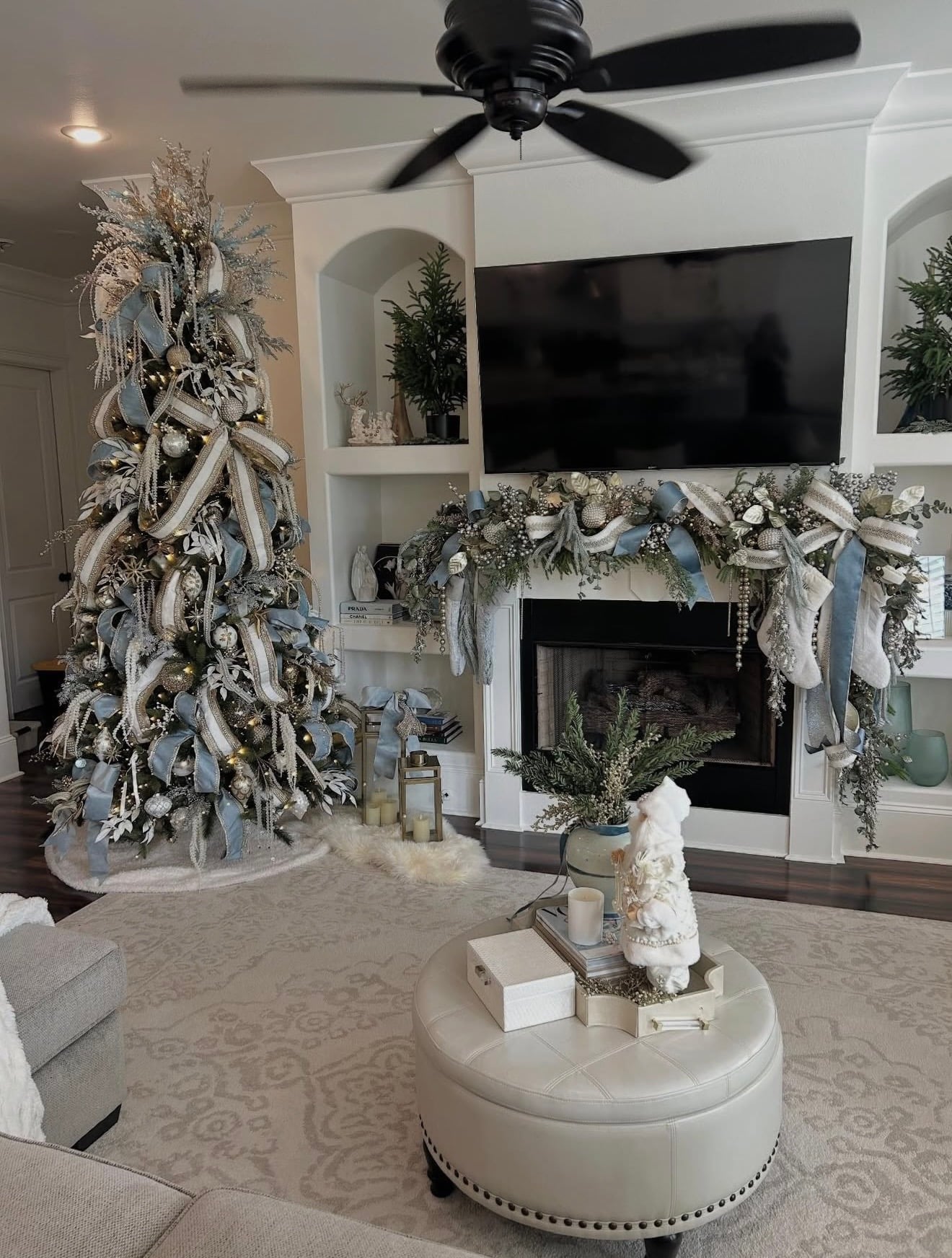 Hampton-style blue Christmas tree displayed in a living room with elegant blue ornaments, soft neutral accents, and warm holiday lighting.