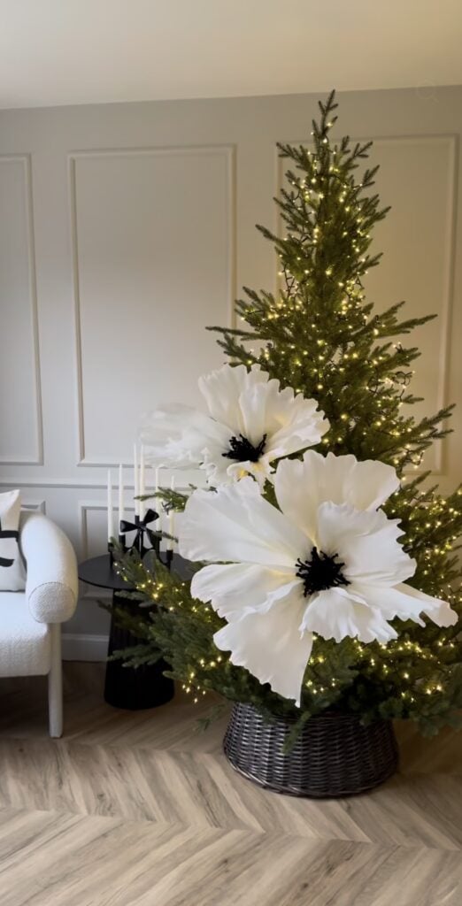 Minimalist Christmas tree decorated with oversized black and white flowers for a simple, graphic holiday look.