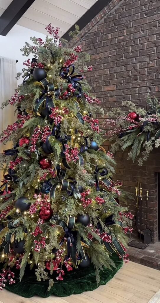 Navy blue and red Christmas tree decorated with plaid ribbon, traditional ornaments, warm lights, and classic Ralph Lauren-inspired details.