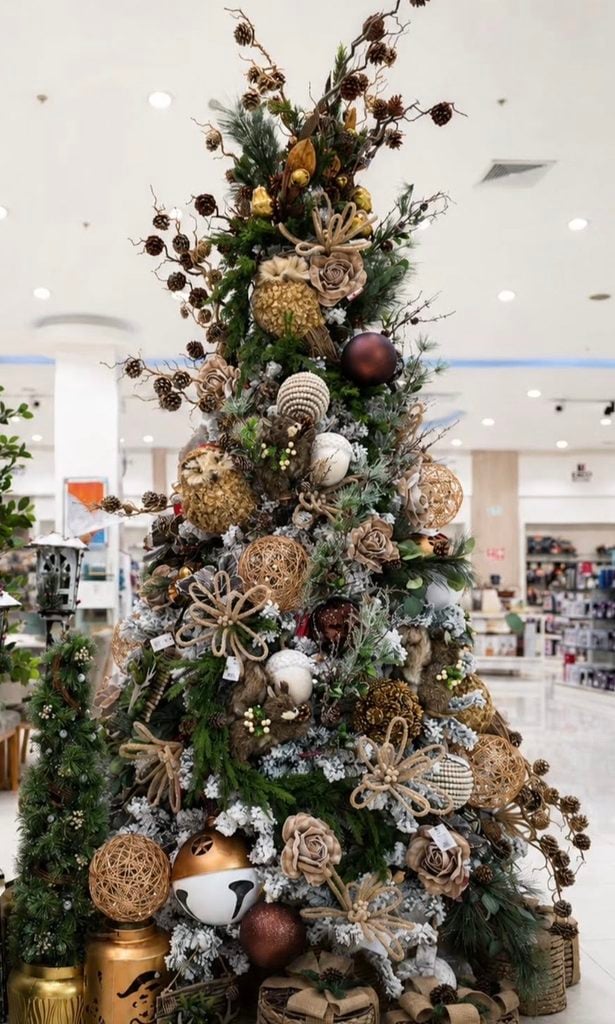Neutral Christmas tree decorated with natural elements, greenery, wood tones, pinecones, and soft earthy ornaments.