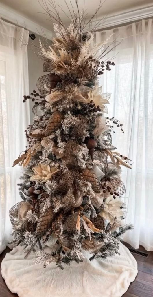 Neutral Christmas tree decorated with natural greenery, soft neutral ornaments, wood accents, and layered organic details.