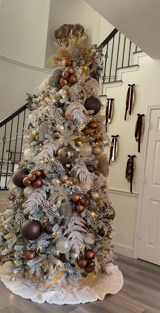 Glam neutral Christmas tree decorated with gold, brown, bronze, and champagne ornaments for an elegant holiday look.