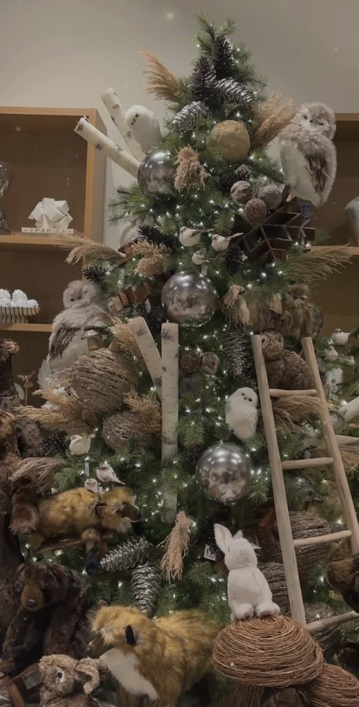 Woodland neutral Christmas tree decorated with wood sticks, natural textures, forest creatures, and earthy ornaments.