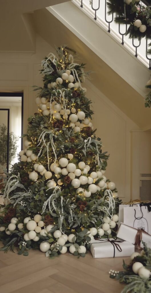 Natural floral Christmas tree styled with organic greenery, flowers, branches, and botanical textures woven through the tree.