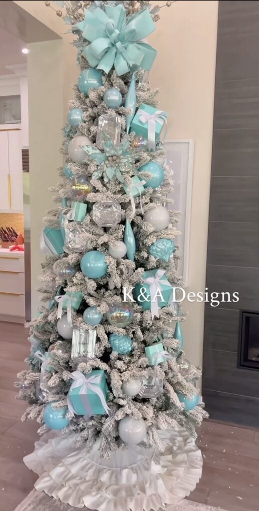 Turquoise blue Christmas tree decorated with aqua ornaments, coordinating ribbon, bright metallic accents, and glowing lights.