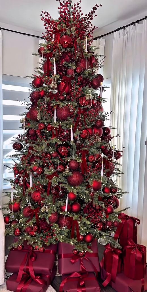 Elegant burgundy Christmas tree decorated with deep wine ornaments, rich ribbon, berry accents and warm white lights.