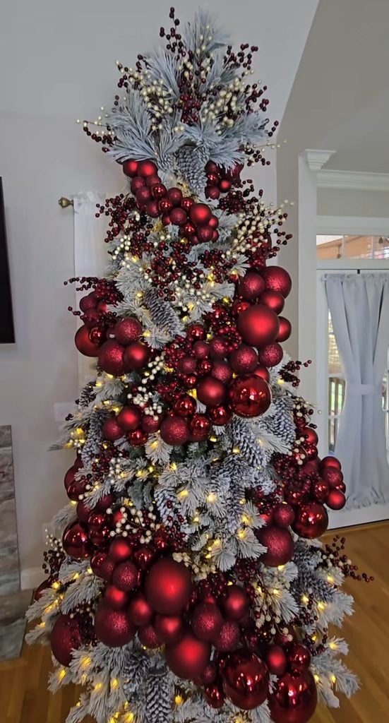 Burgundy and silver Christmas tree with frosted branches, deep red ornaments, icy metallic accents and warm lights.