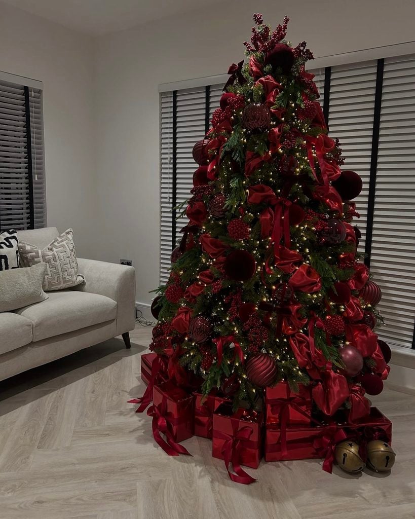 Color-drenched burgundy Christmas tree layered with wine, maroon and deep red ornaments, ribbon and berry accents.